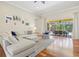 Bright living room with hardwood floors, comfortable seating, and large sliding doors to the outdoor patio at 6216 Donnington Ct, Sarasota, FL 34238