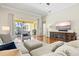 Comfortable living room featuring a large TV, hardwood floors, and neutral tones at 6216 Donnington Ct, Sarasota, FL 34238