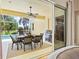 Outdoor patio with a dining table, grill, and view of the pool and lush landscaping at 6216 Donnington Ct, Sarasota, FL 34238