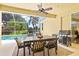 Screened-in patio with a dining table, grill, and relaxing view of the pool and lake at 6216 Donnington Ct, Sarasota, FL 34238
