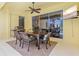 Outdoor patio area with dining table, chairs, ceiling fan, grill and sliding glass doors to indoors at 6216 Donnington Ct, Sarasota, FL 34238