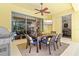 Outdoor patio area with dining table, chairs, ceiling fan, grill and sliding glass doors to indoors at 6216 Donnington Ct, Sarasota, FL 34238