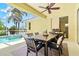 Outdoor patio featuring a dining table and chairs with a fan and grill next to a pool with fountain at 6216 Donnington Ct, Sarasota, FL 34238