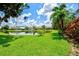 Scenic pond view surrounded by lush green grass, mature trees, and vibrant landscaping creating a peaceful retreat at 6216 Donnington Ct, Sarasota, FL 34238