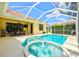 Pool and hot tub with screened in enclosure and view of patio, landscaping, and blue skies at 6216 Donnington Ct, Sarasota, FL 34238