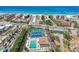 Overhead view showcasing blue tennis courts, a swimming pool, and nearby beaches, set amidst a vibrant coastal community at 6415 Midnight Pass Rd # 502, Sarasota, FL 34242