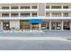 Building entrance with a blue awning and multiple covered parking spots under the building at 6415 Midnight Pass Rd # 502, Sarasota, FL 34242
