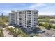 Exterior view of a beachfront condo with parking, beautiful landscaping and water views at 6415 Midnight Pass Rd # 502, Sarasota, FL 34242