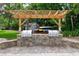 Outdoor kitchen and entertainment area featuring built-in grills, pergola, and seating at 6415 Midnight Pass Rd # 502, Sarasota, FL 34242