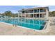 Community pool with lounge chairs, shade umbrellas, and the community center building at 6415 Midnight Pass Rd # 502, Sarasota, FL 34242