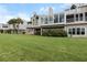 Expansive backyard with lush lawn and a modern home featuring large windows at 65 Tidy Island Blvd, Bradenton, FL 34210