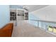 Bright loft area with built-in bookshelves and a glass railing overlooking the lower level at 65 Tidy Island Blvd, Bradenton, FL 34210