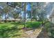 Serene backyard features lush green grass, mature trees, and a view of surrounding properties at 6916 W Country Club N Dr # 9B, Sarasota, FL 34243
