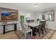 The dining room features a painting, a stylish table, and views of the backyard at 6916 W Country Club N Dr # 9B, Sarasota, FL 34243