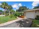 The home features a well-kept lawn, mature palm trees, and a brick walkway leading to a single-car garage at 6916 W Country Club N Dr # 9B, Sarasota, FL 34243