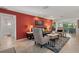 Beautifully decorated living room featuring tiled floors, red accent wall, and plenty of comfortable seating at 6916 W Country Club N Dr # 9B, Sarasota, FL 34243