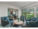 Comfortable sitting area with stylish chairs, marble-top table, and sun-filled windows at 6916 W Country Club N Dr # 9B, Sarasota, FL 34243