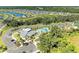 Aerial view showcasing the community's clubhouse, pool, parking area, and surrounding homes and landscaping at 7160 Amelia River Dr, Parrish, FL 34219