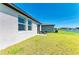 Home's backyard featuring green grass, a patio with seating, lake view, and a light colored exterior at 7160 Amelia River Dr, Parrish, FL 34219