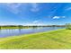 Expansive backyard view of pond and distant homes, showcasing the community's serene setting at 7160 Amelia River Dr, Parrish, FL 34219