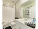 Bathroom with white cabinets, black and white accents, toilet, shower with a white curtain, and a large mirror at 7160 Amelia River Dr, Parrish, FL 34219