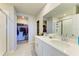 A well-lit bathroom features double sinks, a shower, and access to a walk-in closet at 7160 Amelia River Dr, Parrish, FL 34219