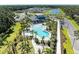 Aerial view of the resort-style pool with palm trees, lounge chairs, and a clubhouse at 7160 Amelia River Dr, Parrish, FL 34219