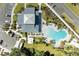 Overhead view of the community's kidney-shaped pool and clubhouse with parking area, landscaped grounds, and more at 7160 Amelia River Dr, Parrish, FL 34219