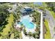 Aerial view of a clubhouse and an inviting, resort-style pool, surrounded by lush landscaping and ample lounge seating at 7160 Amelia River Dr, Parrish, FL 34219