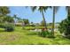 A serene backyard and pond provide a relaxing view with lush landscaping and colorful plants at 8239 Cypress Hollow Dr, Sarasota, FL 34238