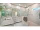 Bathroom showcasing double sinks, stone countertops, tiled floors and a glass enclosed shower at 8239 Cypress Hollow Dr, Sarasota, FL 34238
