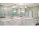 Bathroom featuring double sinks, stone countertops, and glass enclosed shower at 8239 Cypress Hollow Dr, Sarasota, FL 34238