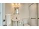 Bathroom featuring a pedestal sink, ornate mirror, and tiled shower with handrail at 8239 Cypress Hollow Dr, Sarasota, FL 34238