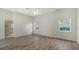 An empty bedroom boasts hardwood floors, two windows, base molding, and an ensuite bathroom at 8239 Cypress Hollow Dr, Sarasota, FL 34238