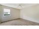 A bright, empty bedroom with wood-look floors, a ceiling fan, and a window offering natural light and a view at 8239 Cypress Hollow Dr, Sarasota, FL 34238