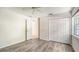 Bedroom featuring wood floors, neutral walls, ceiling fan and a large closet at 8239 Cypress Hollow Dr, Sarasota, FL 34238