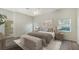 Serene bedroom with neutral decor, an upholstered bed, and a view of the landscaped yard at 8239 Cypress Hollow Dr, Sarasota, FL 34238