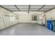 Spacious garage with epoxy flooring, storage cabinets, utility hookups, and natural light at 8239 Cypress Hollow Dr, Sarasota, FL 34238