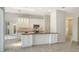 Open kitchen features white cabinets, an island with breakfast bar, and stainless steel appliances at 8239 Cypress Hollow Dr, Sarasota, FL 34238