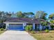 Single-story home with attached garage, mature landscaping and a paved driveway at 8260 Berkeley Manor Blvd, Spring Hill, FL 34606