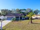 Charming single-story home with a well-maintained lawn, mature trees, and a two-car garage at 8260 Berkeley Manor Blvd, Spring Hill, FL 34606