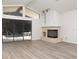 Bright living room with fireplace, sliding glass doors to the pool and modern flooring at 8260 Berkeley Manor Blvd, Spring Hill, FL 34606