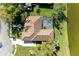 Overhead view of a home with a screened pool, tile roof, and well-maintained landscaping near a lake at 8315 Eagle Xing, Sarasota, FL 34241