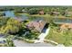 Aerial view of waterfront property with screened pool, tile roof, and lush landscaping on a sunny day at 8315 Eagle Xing, Sarasota, FL 34241