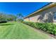 Well-manicured backyard featuring lush lawn, landscaping, and the home's exterior at 8315 Eagle Xing, Sarasota, FL 34241