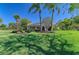 Lush backyard with mature landscaping, palm trees, and a spacious lawn surrounding the home at 8315 Eagle Xing, Sarasota, FL 34241