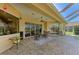 Covered lanai with brick pavers, ceiling fan, seating, and view of outdoor living area at 8315 Eagle Xing, Sarasota, FL 34241