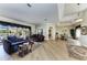 Open concept living room featuring hardwood floors, elegant furniture, and views of the pool area through sliding glass doors at 8315 Eagle Xing, Sarasota, FL 34241