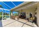 Outdoor patio features a covered seating area, outdoor kitchen, and screened-in porch with views of the lake at 8315 Eagle Xing, Sarasota, FL 34241