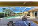 Covered patio overlooking screened pool area features dining table and chairs, and relaxing lounge chairs at 8315 Eagle Xing, Sarasota, FL 34241